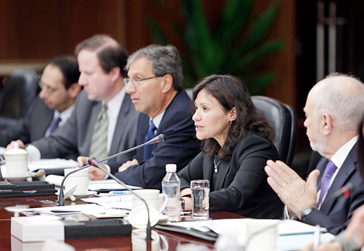 Federal Trade Commission Chairwoman Edith Ramirez, seated at the conference table, speaking to those gathered for the meetings